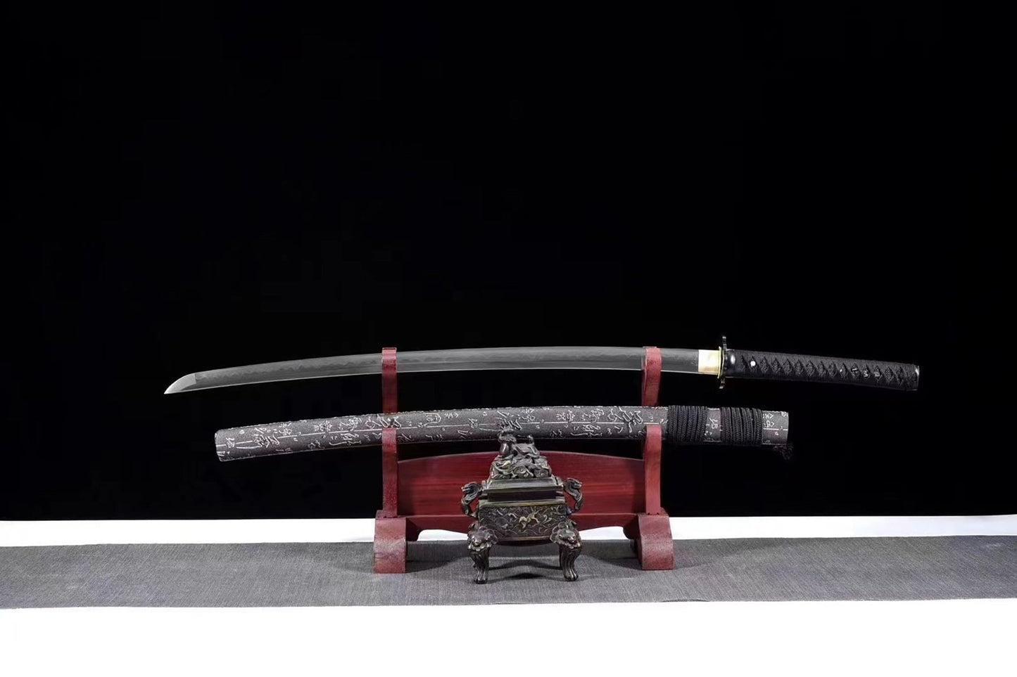 a japanese sword on a stand with a black background